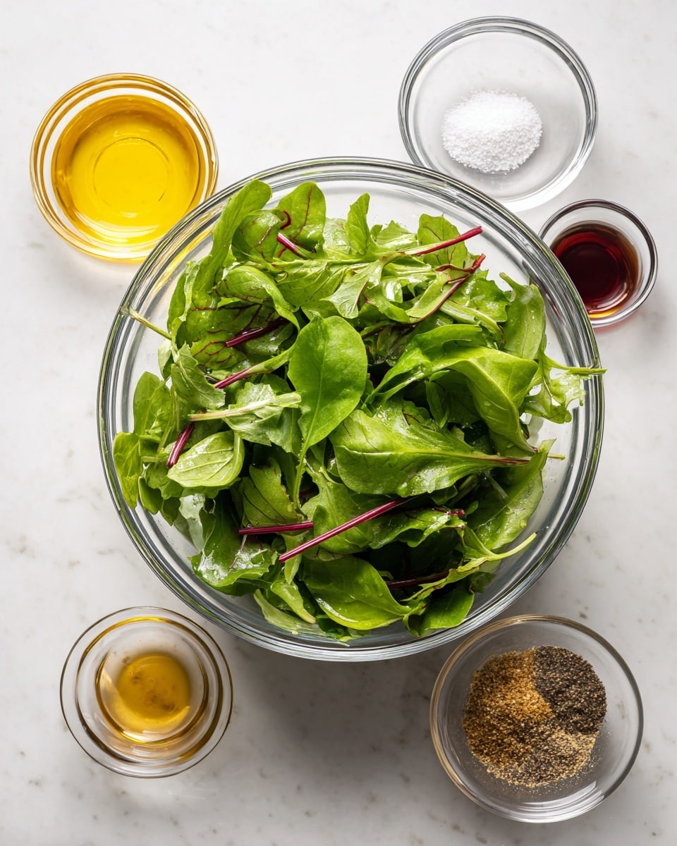 A clear glass bowl filled with fresh green leafy salad with some red stems, placed on a white marbled surface; around the bowl, four small clear glass bowls hold different ingredients: golden yellow oil at the top left, white salt and black pepper mix at the top right, deep red vinegar below the oil, and coarse textured brown mustard below the vinegar. photo taken with an iphone --ar 4:5 --v 7
