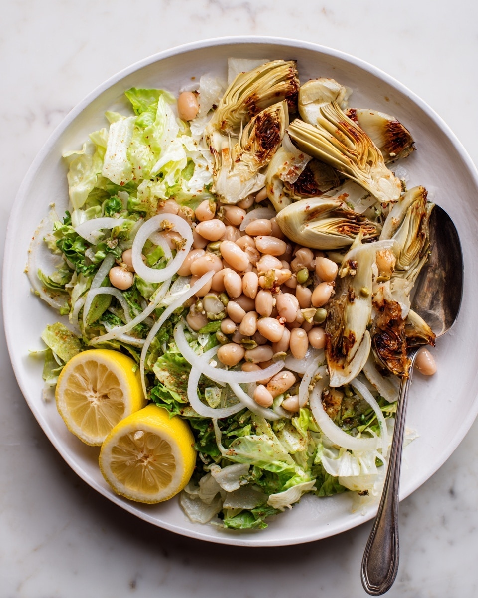 A white plate holds a salad with three main layers: the base is light green shredded lettuce, followed by pale beige white beans scattered throughout. On top, several roasted artichoke pieces with browned edges are placed unevenly. To the left side of the plate, three lemon wedges with bright yellow rinds and juicy segments rest, adding color contrast. The plate sits on a white marbled surface. A small part of a fork is seen on the right edge of the plate. photo taken with an iphone --ar 4:5 --v 7