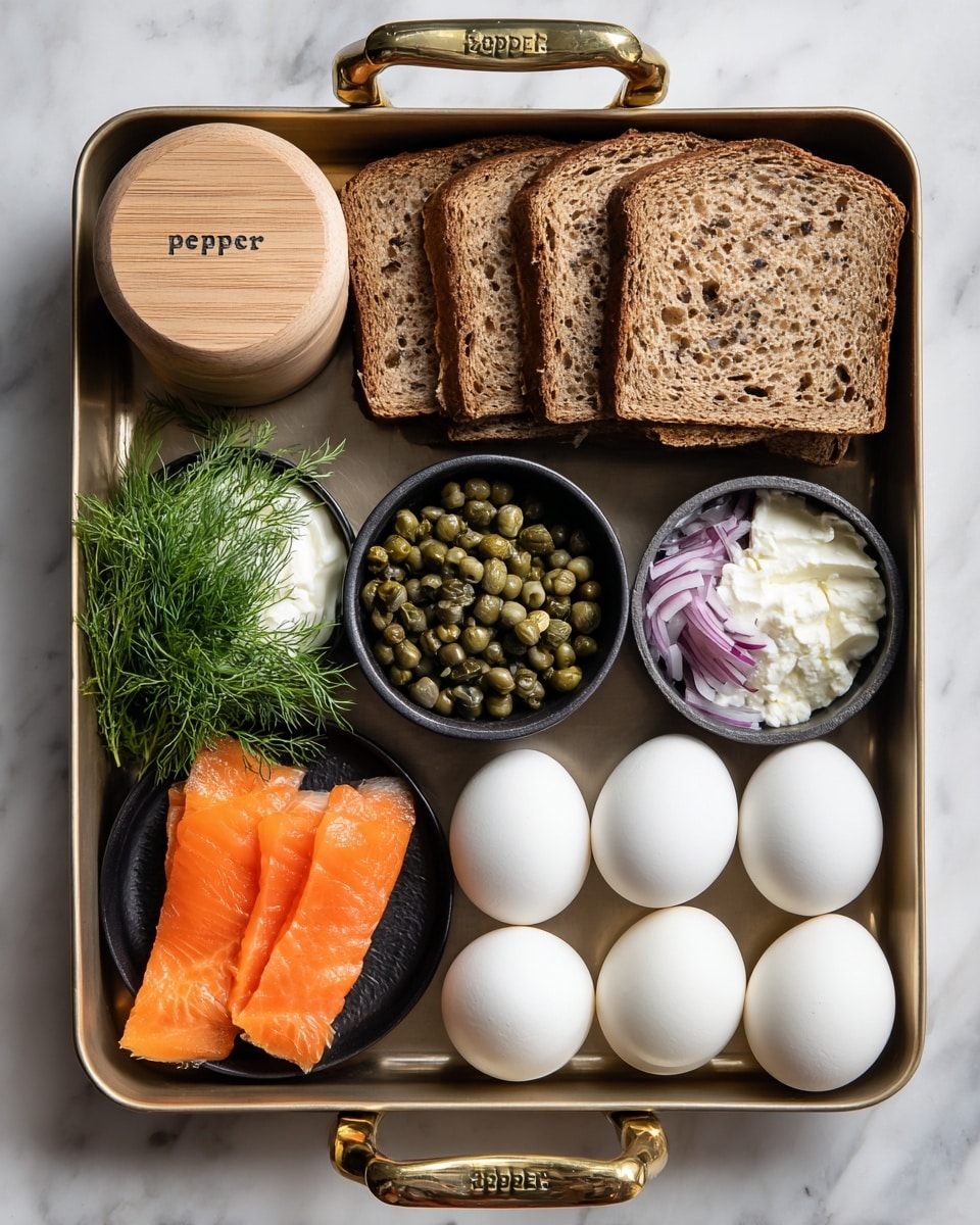 A metal tray holds several food items arranged neatly: four slices of brown bread stacked on the right, four white boiled eggs below them, a small black bowl of green capers near the eggs, another black bowl with thin purple onion slices in the middle, and a small black bowl of white cream cheese above the onions. On the left side, there is a small black dish with two bright orange slices of smoked salmon, placed next to fresh green dill sprigs. A wooden container with