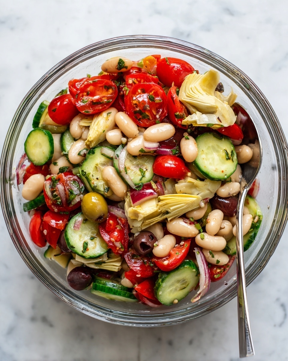 A clear glass bowl sits on a white marbled surface filled with a fresh salad made of several colorful layers. The base layer has chunky cucumber pieces in dark and light green with a firm texture. Mixed in are thick slices of radishes with white centers and red edges scattered evenly. Next, there are small, off-white beans spread throughout along with pale yellow artichoke hearts that have a tender look. Bright red cherry tomato halves and finely chopped red bell pepper pieces add vibrant splashes of color. Sliced green olives with pimentos are also visible, adding round shapes and a green tone. Fresh green parsley is sprinkled on top, giving the dish a fresh garnish look. A silver spoon rests inside the bowl ready for serving. Photo taken with an iphone --ar 4:5 --v 7