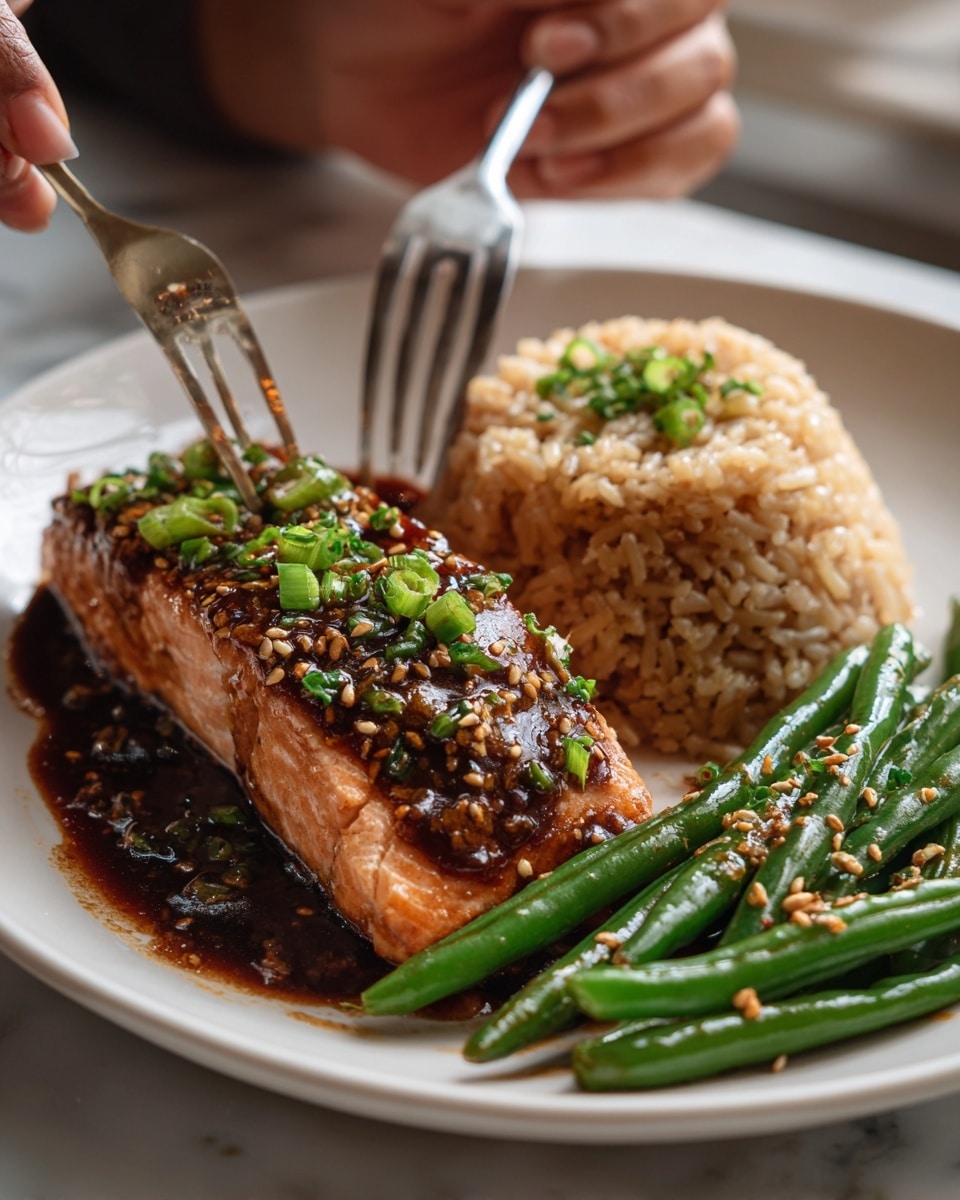 A white plate on a white marbled surface holds a meal with three parts: on the left is a thick salmon fillet glazed with a shiny brown sauce and sprinkled with light tan sesame seeds and small green onion pieces, a small piece of salmon is cut off and held on a silver fork at the bottom; in the middle is a mound of light brown cooked rice with some darker brown sauce on top; on the right is a small pile of bright green cooked green beans drizzled with the same shiny brown sauce and also sprinkled with sesame seeds, photo taken with an iphone --ar 4:5 --v 7