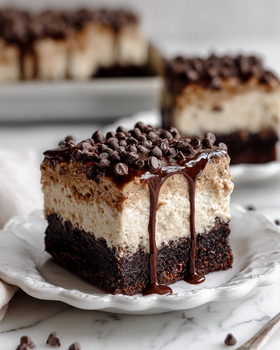 A square dessert piece on a white scalloped plate shows two clear layers: a thick dark brown, moist cake layer at the bottom with a soft, crumbly texture, topped by a thick light brown creamy layer with a fluffy texture. The top layer is sprinkled generously with small dark brown chocolate chips and drizzled with shiny dark chocolate syrup that runs slightly down the sides. The background features a blurred view of more pieces on a baking tray, all on a white marbled surface. Photo taken with an iphone --ar 4:5 --v 7