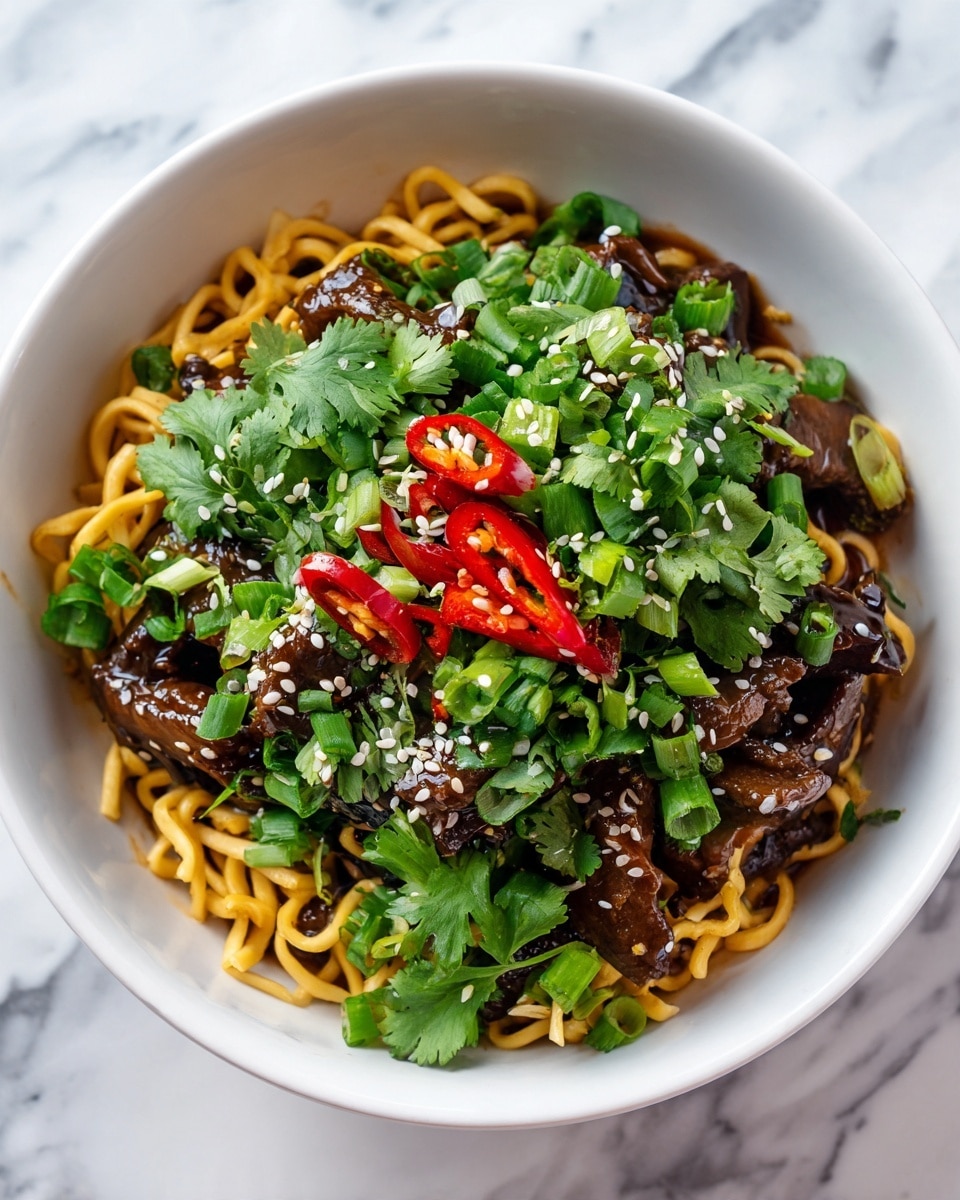 This image shows a white bowl filled with three main layers. The bottom layer is made of cooked curly yellow noodles with a shiny, soft texture. On top of the noodles, there is a generous pile of dark brown beef strips coated in a glossy sauce with small red chili pieces mixed in. Scattered over the beef and noodles are bright green chopped scallions and fresh cilantro leaves. White sesame seeds are sprinkled across the top, adding a light contrast. The background and surface feature a white marbled texture. photo taken with an iphone --ar 4:5 --v 7